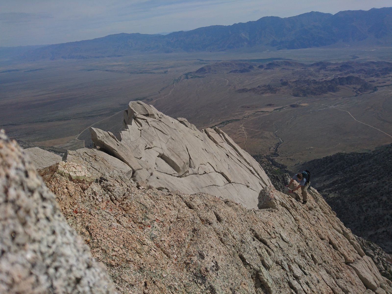 View of the maountain ridge and a climber coming up. The valley is in the background.