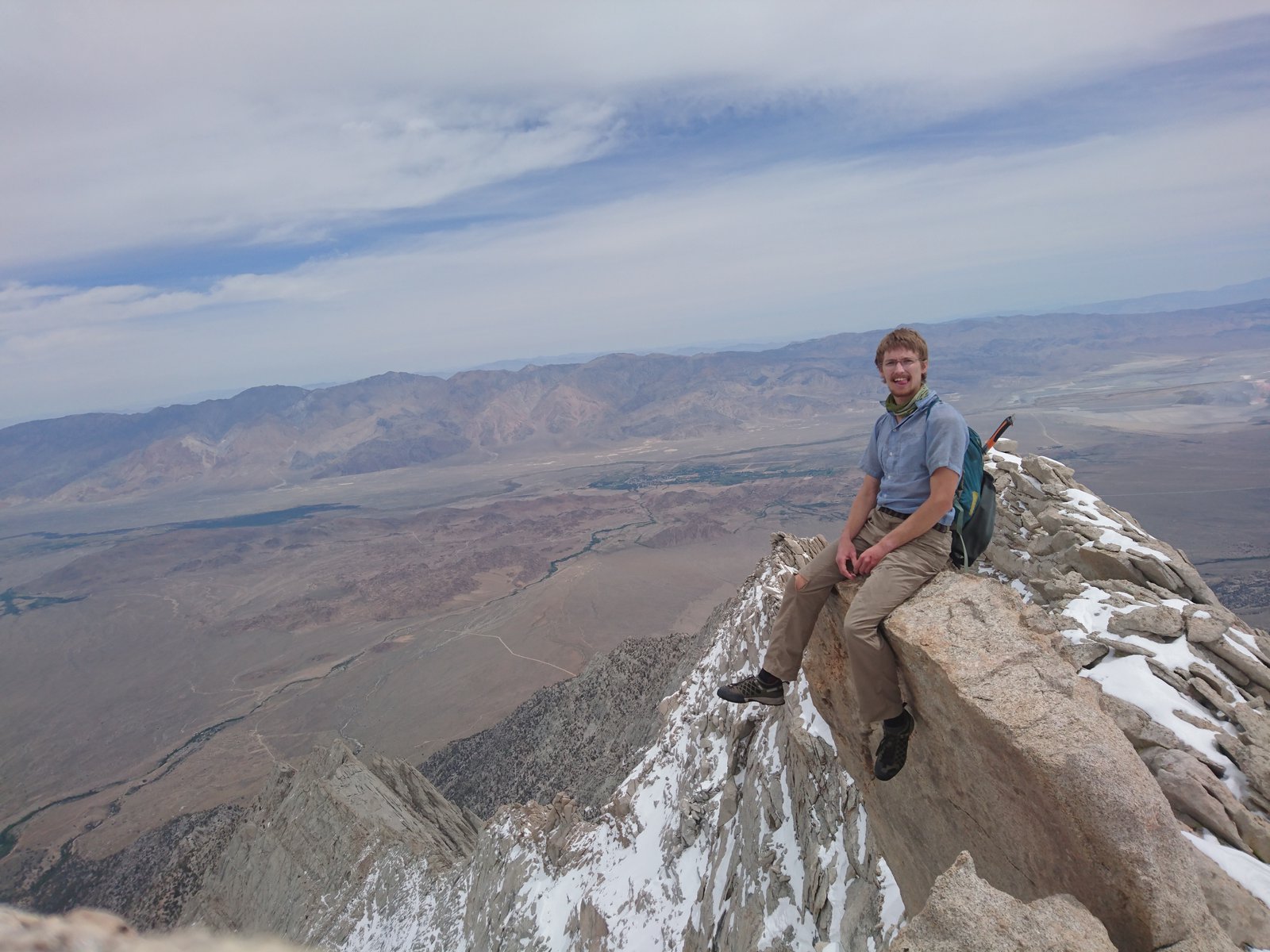 Dustin sitting at the top of the mountain on a rock, overlooking the Owens Valley.