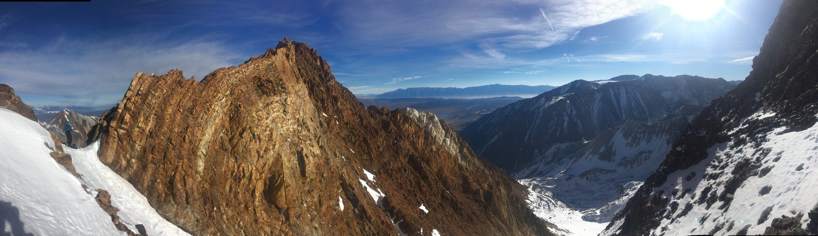 Panoramic view of the couloir, rocky mountaintops, and almost clear skies.