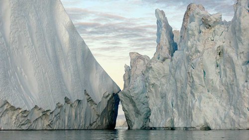 Two large glaciers in the ocean with a small channel of water in between the two