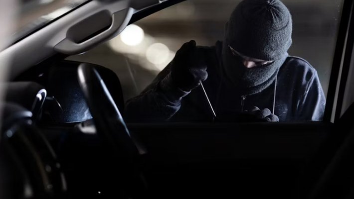 masked person breaking into car