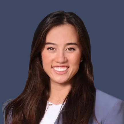 Madison Quan smiling in front of a dark blue background.