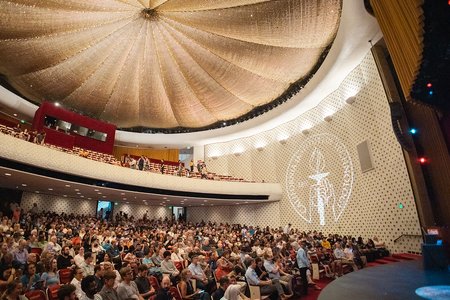 The audience assembles in brightly lit Beckman Auditorium