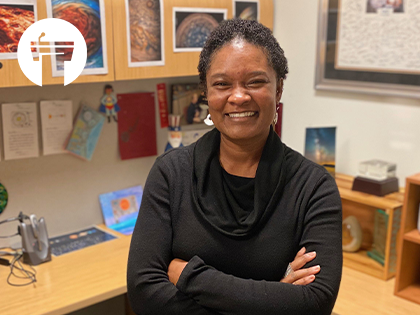 Tracy Drain standing and smiling in front of desk in office