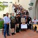 Mentors, mentees, and organizers arranged along a set of stairs outside. One man is sitting in a wheel chair in the lower right corner.