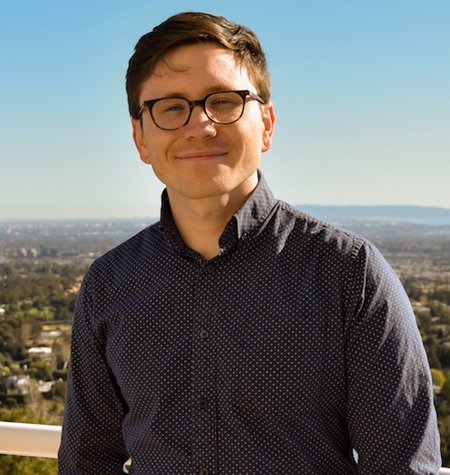 A man in glasses smiles for a photo