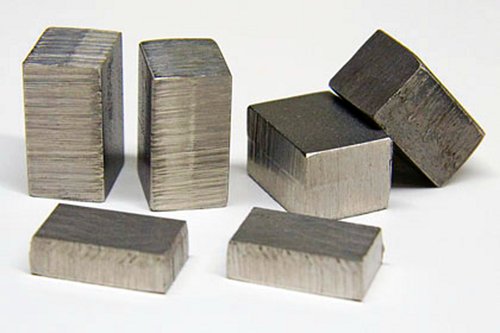 Silvery metal blocks rest on a white surface.