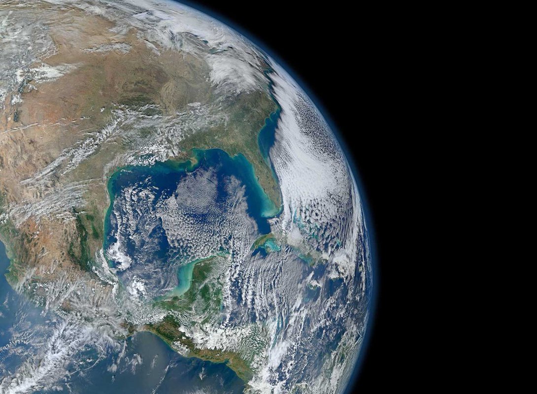 An image of Earth from orbit. Blue ocean and swirling white clouds are seen.