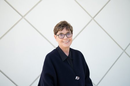 Image of Diana K. Buchwald wearing a black top in front of Beckman Auditorium