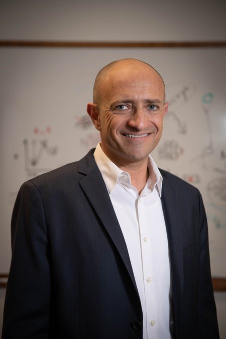 A man in a navy blue suit jacket and white shirt