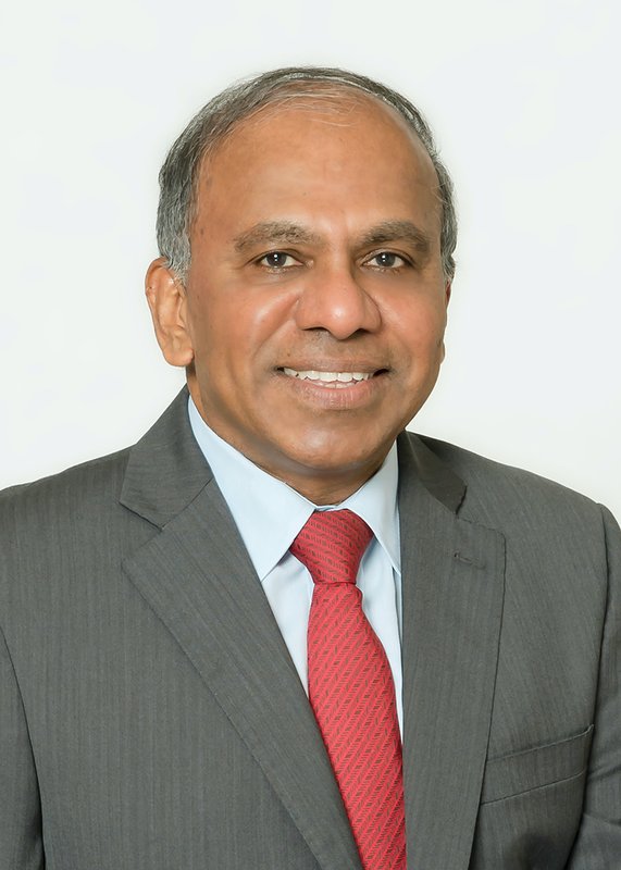 A man in business attire looking into the camera