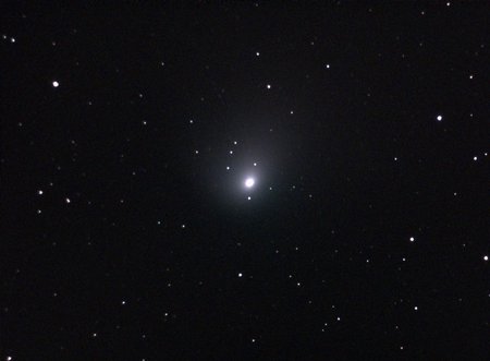 The comet appears as a glowing white blob against a background of stars