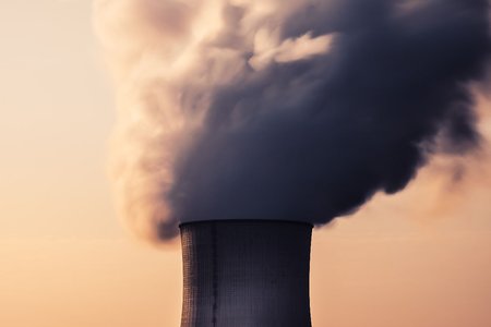Steam billows out of a cooling tower of a power plant