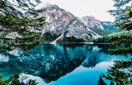 A lake reflects snowy mountains