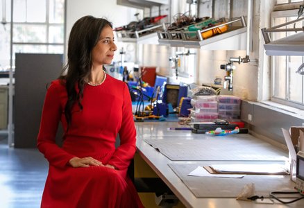 Person in red dress sitting at an engineering lab bench