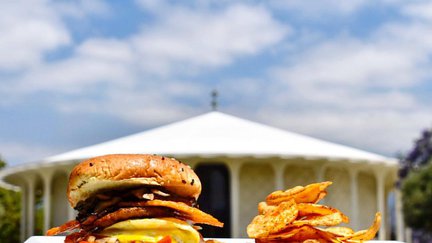 Dining Services cheeseburger and Beckman Auditorium in the background